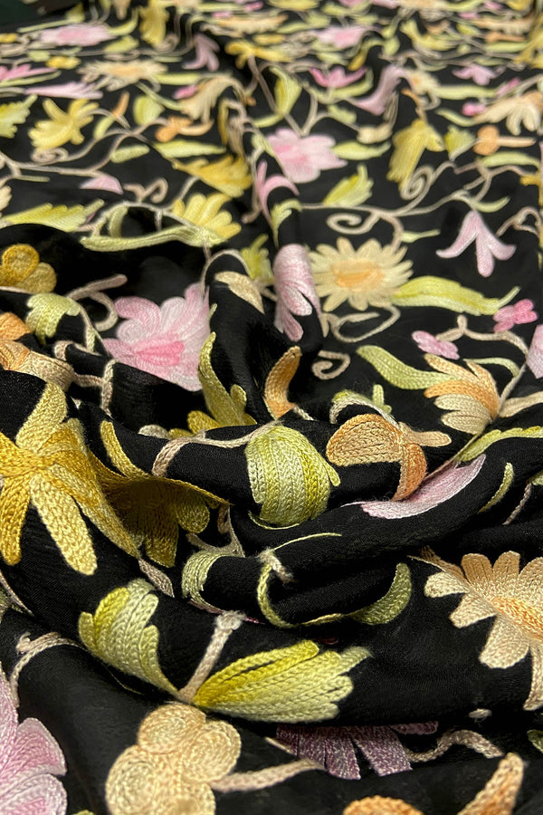 Close-up of black fabric with colorful floral embroidery