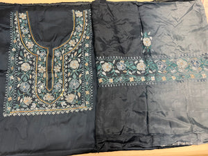 Two pieces of fabric, one with a floral Aari and sequence work in the center and the other with a border featuring the same style of work.