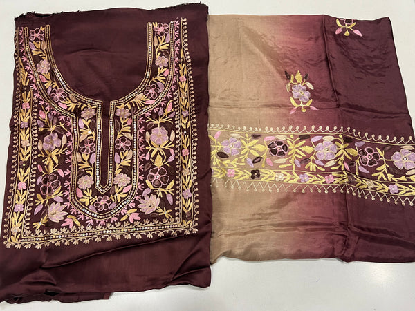 #Wine Two pieces of fabric, one with a floral Aari and sequence work in the center and the other with a border featuring the same style of work.