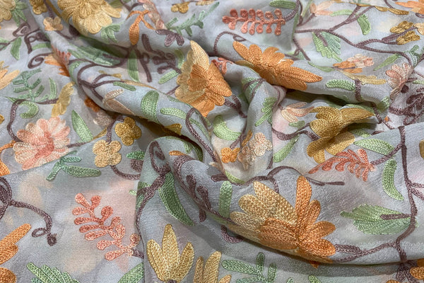 Floral embroidery fabric with a soft focus on patterns and colors.