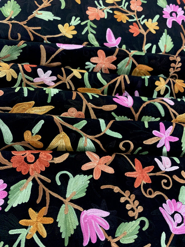 Embroidered fabric with colorful floral patterns on a black background