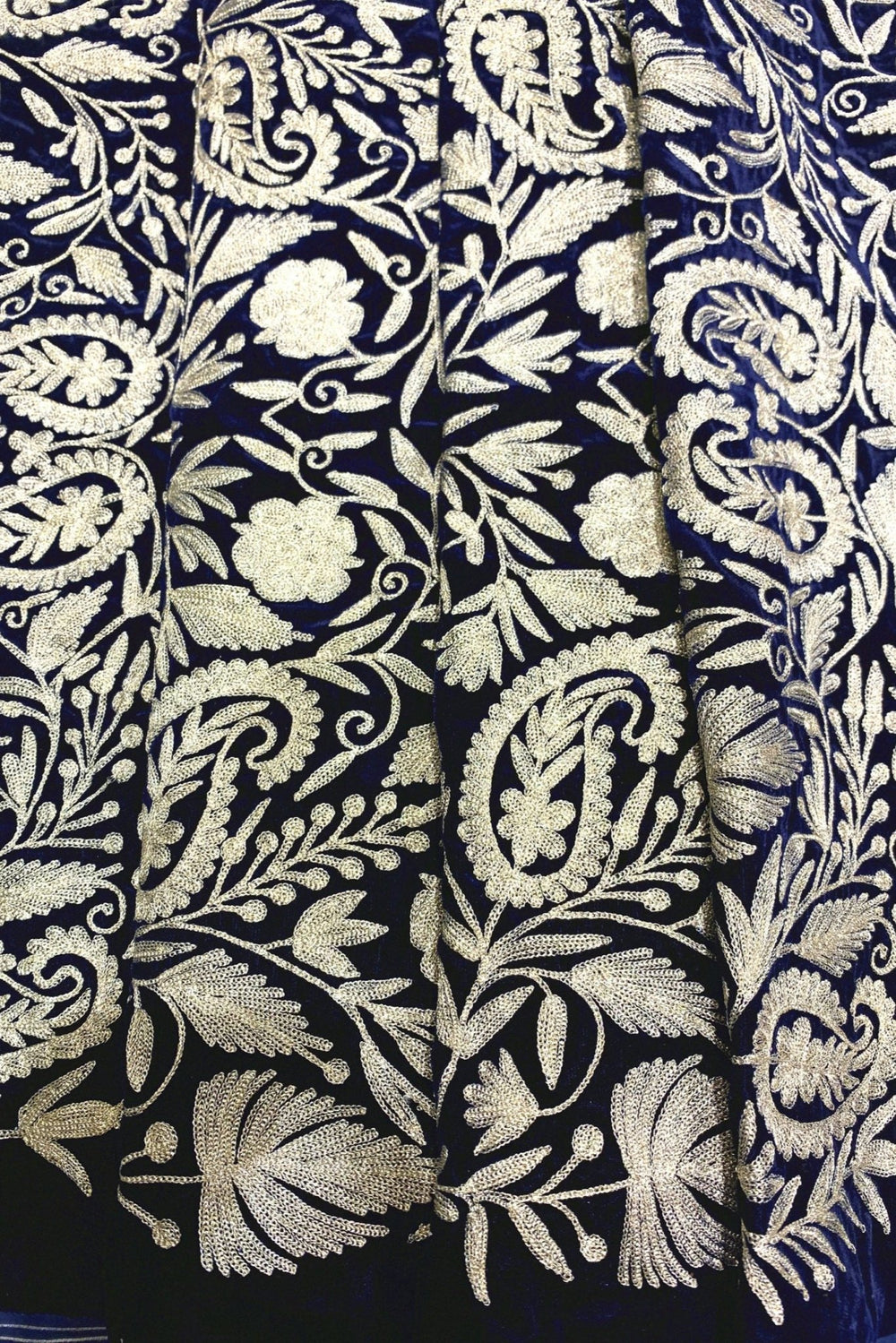 Patterned fabric with intricate designs on a navy background