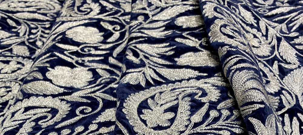 Patterned fabric with intricate designs on a navy background