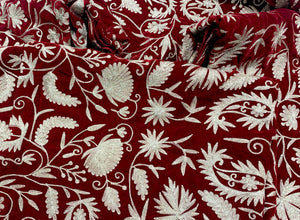 #Red Close-up of red fabric with intricate white floral embroidery
