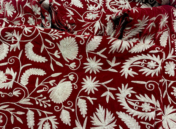 #Red Close-up of red fabric with intricate white floral embroidery