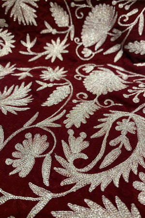 #red Close-up of embroidered fabric with floral patterns on a red background