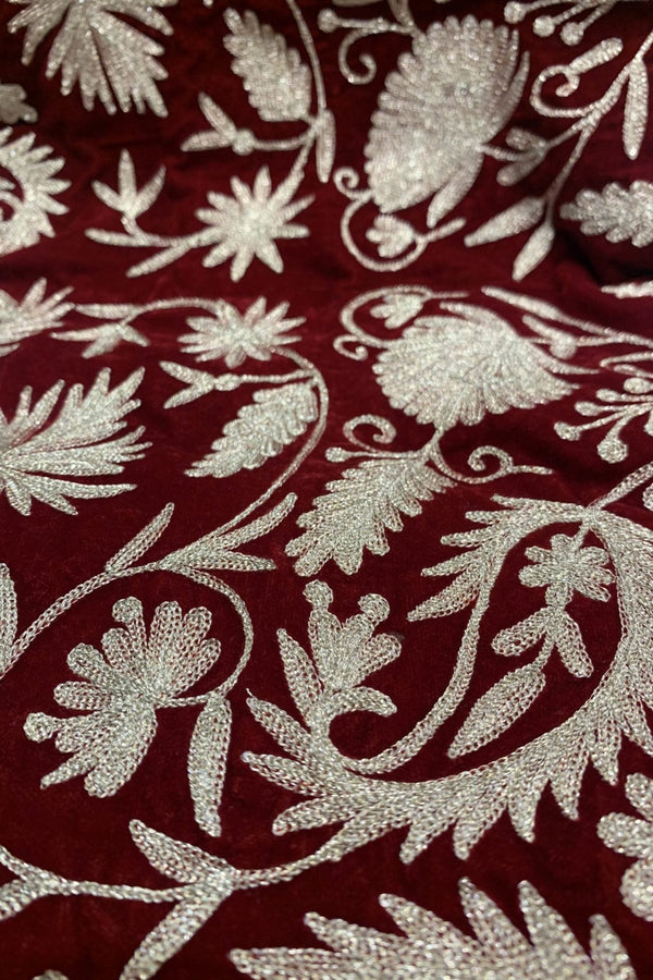 #red Close-up of embroidered fabric with floral patterns on a red background