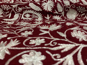 #Red Close-up of embroidered fabric with gold floral patterns on a red background
