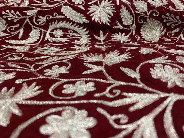 #Red Close-up of embroidered fabric with gold floral patterns on a red background
