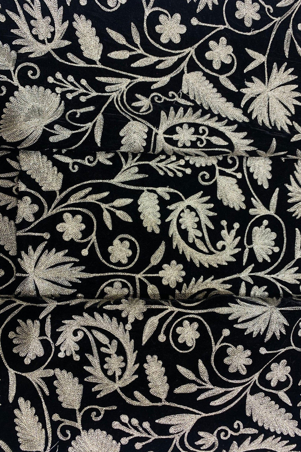 #black Close-up of black fabric with dull gold floral embroidery