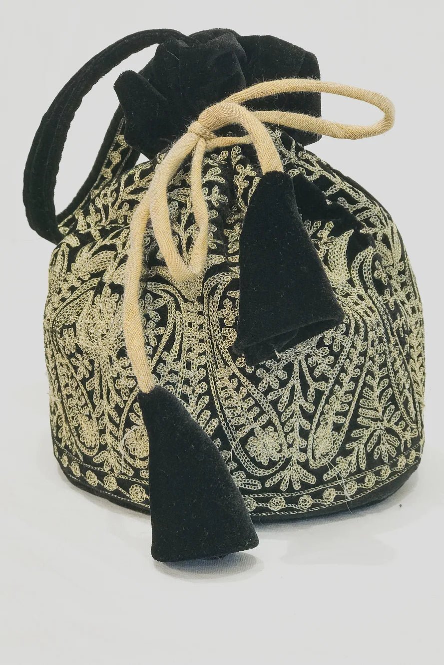 Black and gold patterned drawstring bag with tassels on a white background