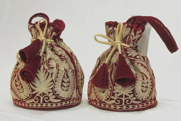 #Maroon Two embroidered fabric bags with red and gold patterns on a white background
