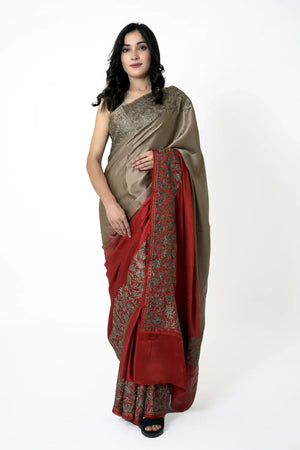 Woman wearing a beige and red saree with a white background