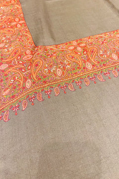 Textile with intricate orange and green paisley pattern on a beige background