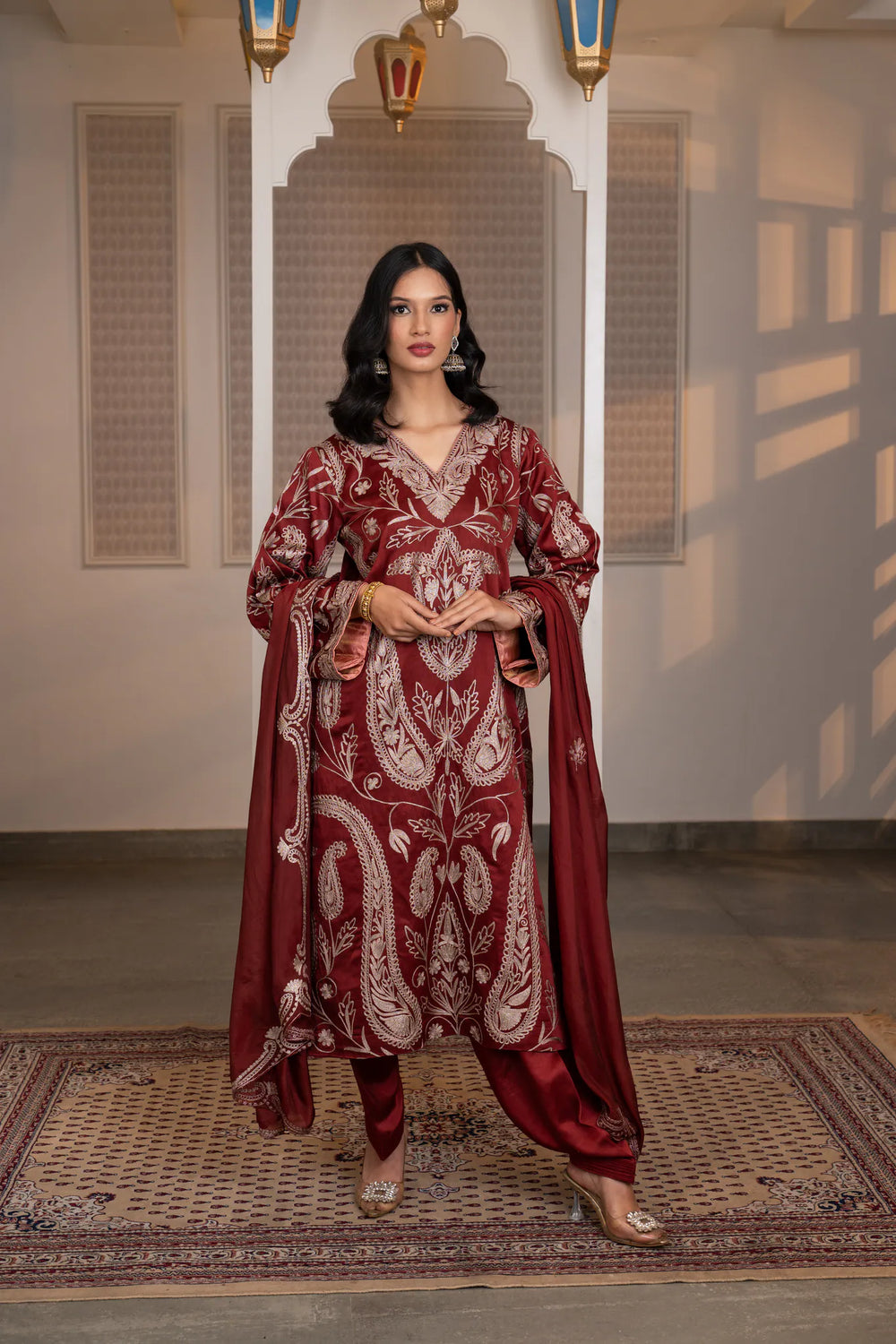 #CrimsonMaroon - linen satin Kashmiri suit set with all-over dull-gold embroidered paisley and floral vine motifs, v-neckline, organza dupatta