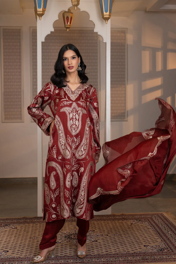 #CrimsonMaroon - Front view of wine kurta with dense dull-gold paisley embroidery, gathered sleeves, and matching salwar; dupatta draped over arms