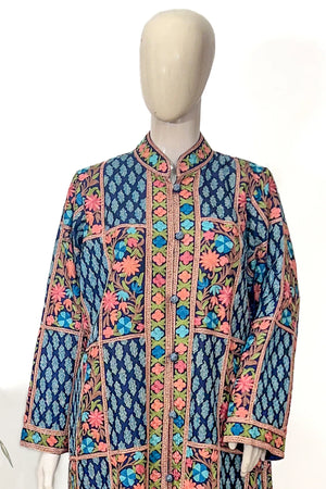 Colorful embroidered jacket on a mannequin against a white background