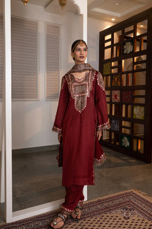 #Maroon - Three-quarter front view of maroon kurta with zari yoke embroidery, embroidered shoulder extension, and tassel-edged cuffs