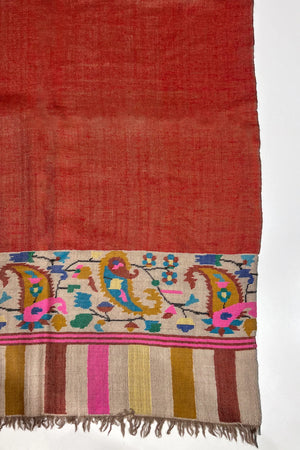 Red fabric with colorful embroidery on a white background