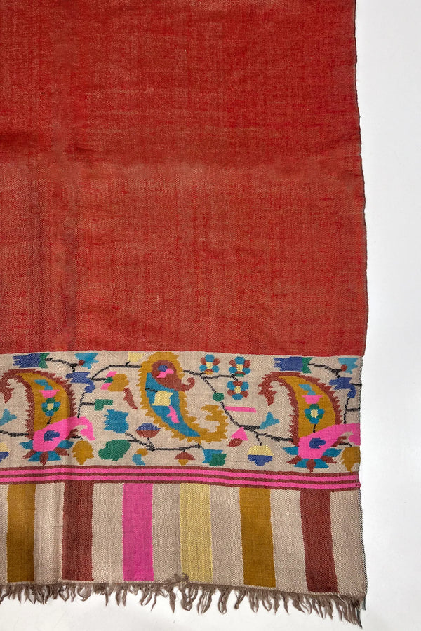 Red fabric with colorful embroidery on a white background