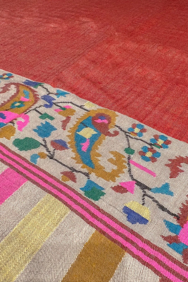 Textile with intricate patterns and colors on a red background
