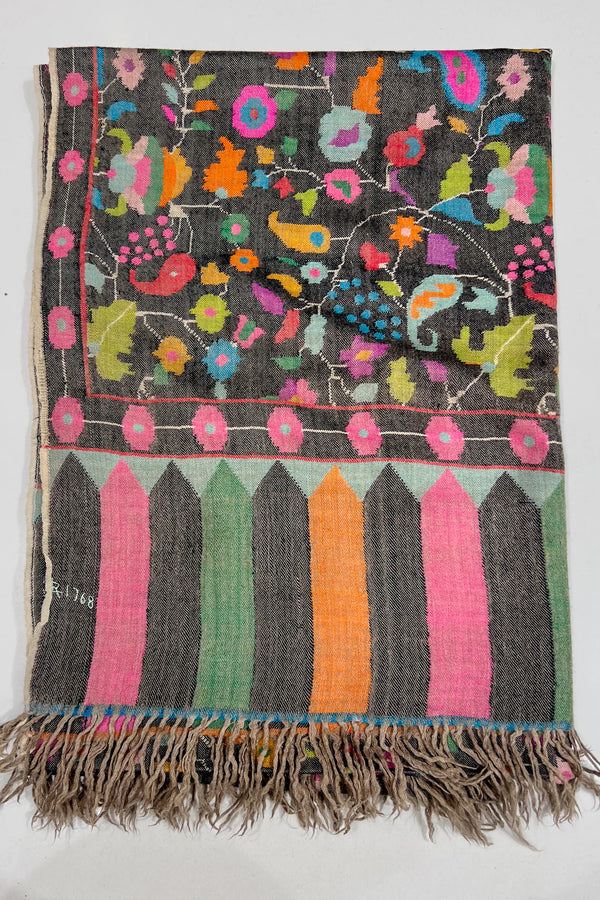 Colorful woven textile with floral patterns on a plain background
