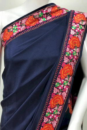 #Navyblue saree with floral border on a mannequin, against a white background.