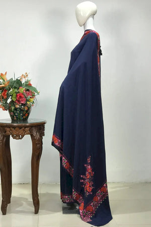 #Navyblue saree with floral border on a mannequin, next to a wooden table with flowers, against a white background.