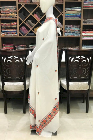 #White saree with colorful border on a mannequin in a store setting