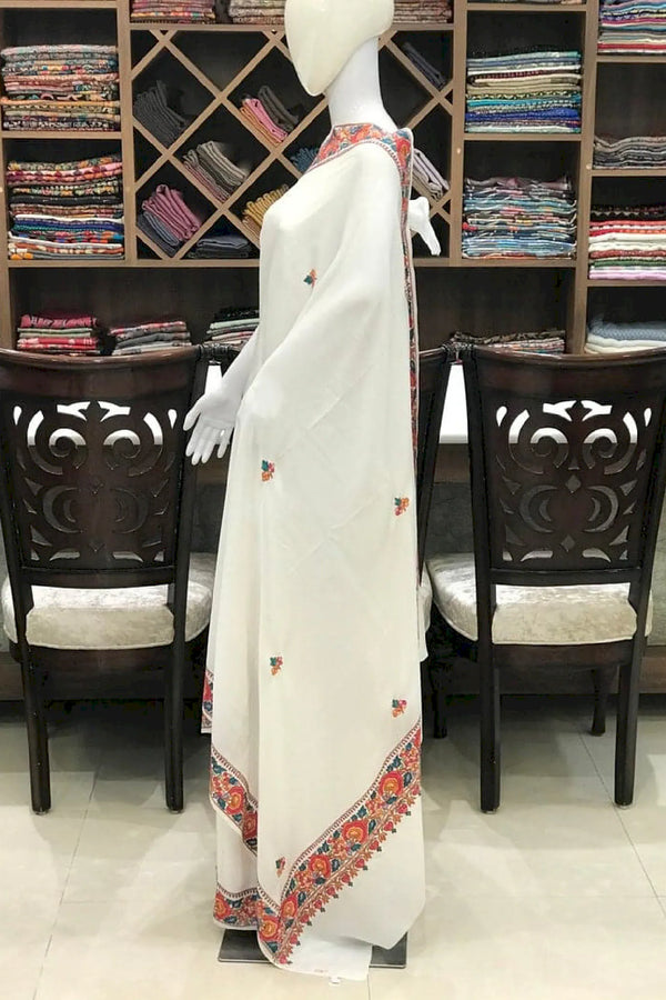 #White saree with colorful border on a mannequin in a store setting