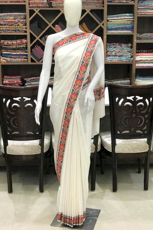 #White saree with colorful border on a mannequin in a store setting