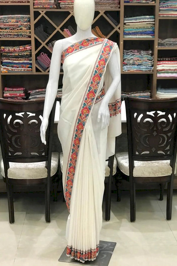 #White saree with colorful border on a mannequin in a store setting