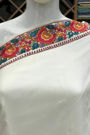 #White saree with colorful border on a mannequin in a store setting