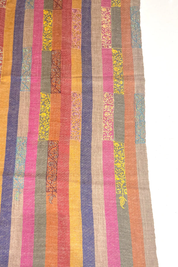 Multicolored striped fabric with patterned patches on a white background