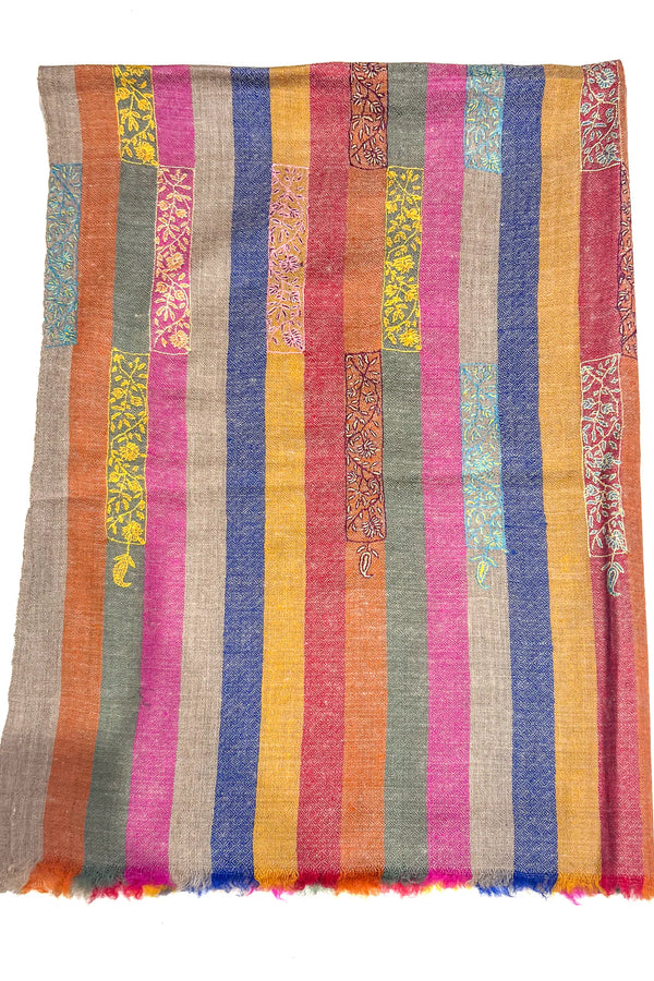 Multicolored striped fabric with patterned sections on a white background