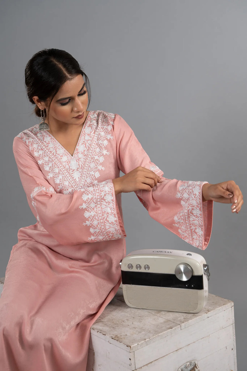 #BlushPink Woman wearing a pink embroidered dress with a gray background