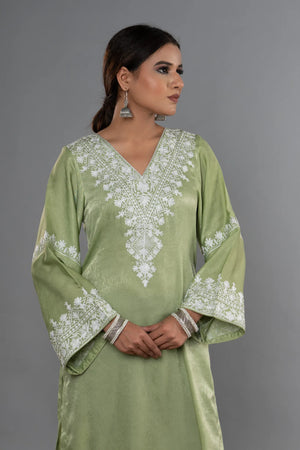 #MossGreen Woman wearing a green embroidered dress against a gray background