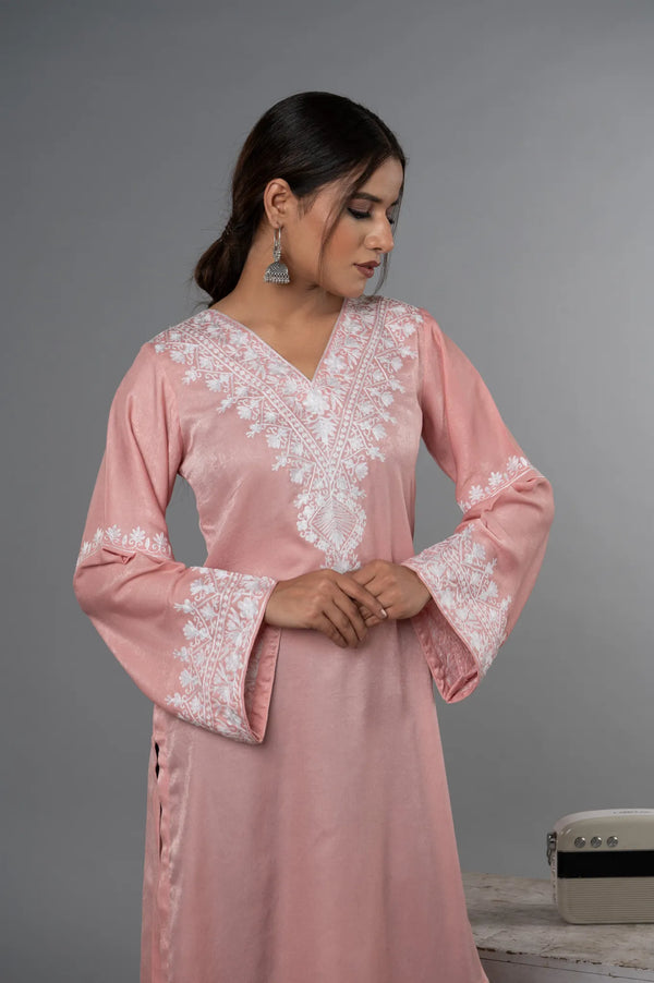#BlushPink Woman wearing a pink dress with white lace details against a gray background