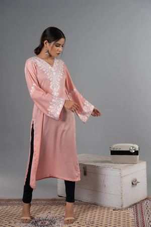 #BlushPink Woman in a pink traditional outfit standing next to a vintage suitcase on a gray background