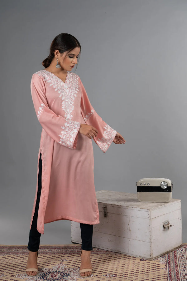 #BlushPink Woman in a pink traditional outfit standing next to a vintage suitcase on a gray background