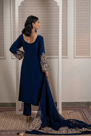 #NavyBlue - Back view of navy blue kurta; plain back with round neckline opening, embroidered cuffs visible, dupatta trailing with embroidered border.