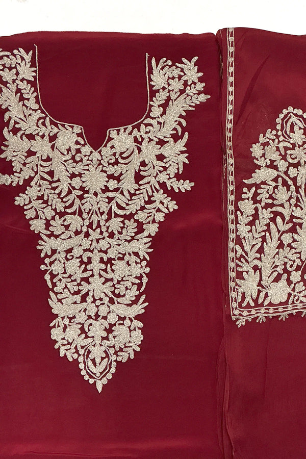 #Maroon - Unstitched maroon Indian crepe kurta fabric with silver-tone zari V-neck panel; sleeve piece with medallion and floral embroidery visible.