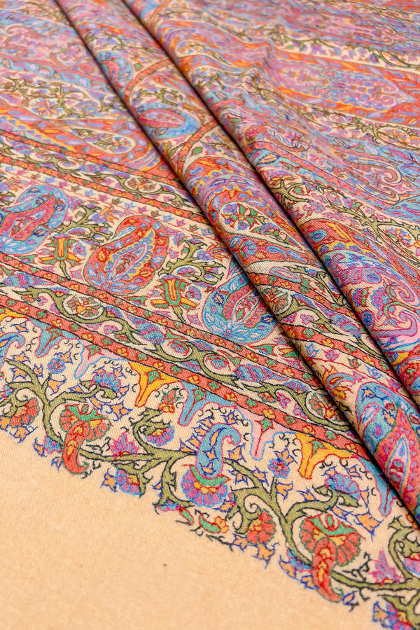 Corner detail of beige pashmina shawl highlighting thread outline embroidery against the hand-painted surface