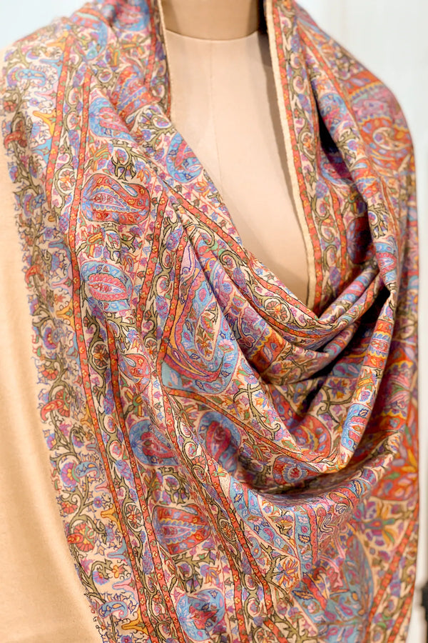 Kalamkari hand-painted motifs with embroidered thread outlines across the surface of a beige pashmina shawl