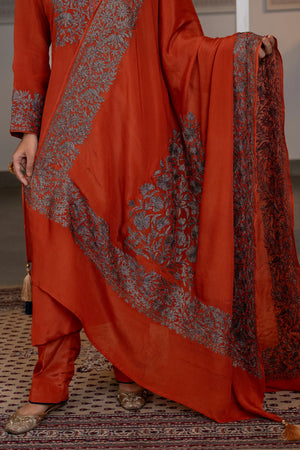 #Rust - Close-up of lower kurta and dupatta showing chevron-shaped floral border and corner medallion with tassel detail
