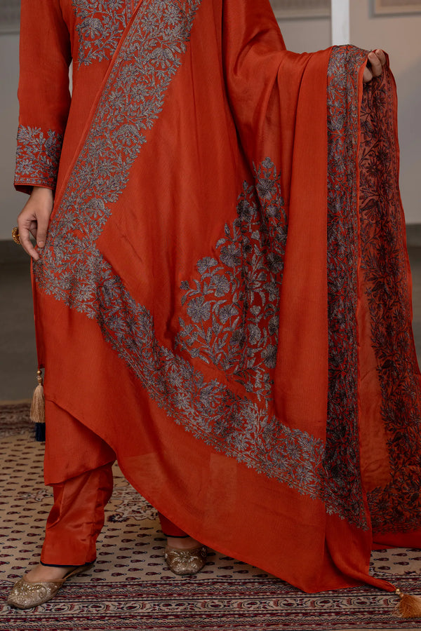#Rust - Close-up of lower kurta and dupatta showing chevron-shaped floral border and corner medallion with tassel detail