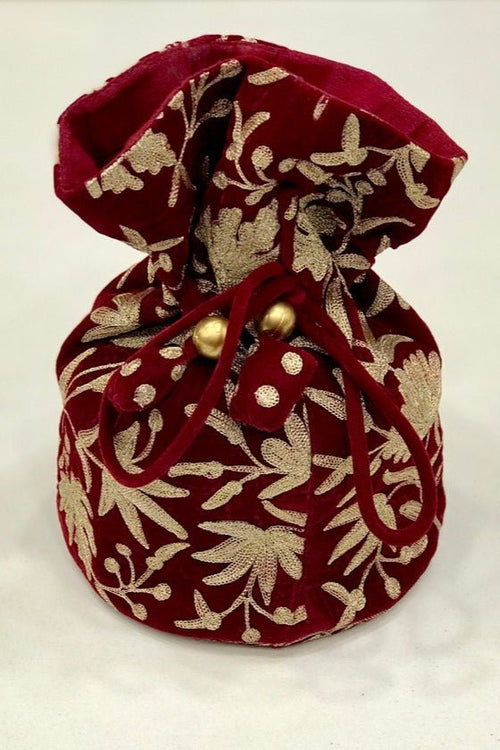 #Red Red fabric pouch with gold embroidery on a white background