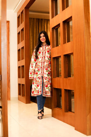 Woman in a floral coat standing in a room with wooden panels