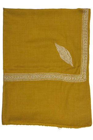 Mustard yellow fabric with intricate gold embroidery on a white background