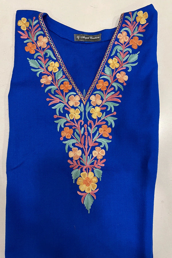 #Blue top with colorful floral embroidery on a white background